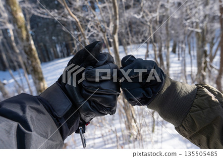 two people putting fists together two people putting fists together 135505485