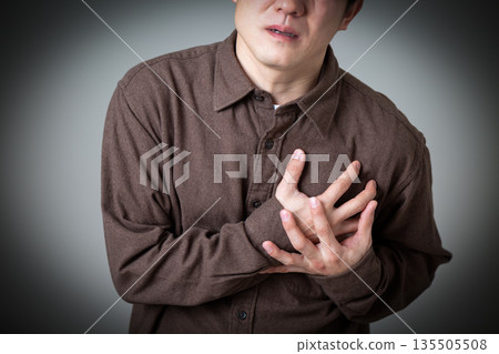 Middle-aged man holding his chest and suffering from pain 135505508