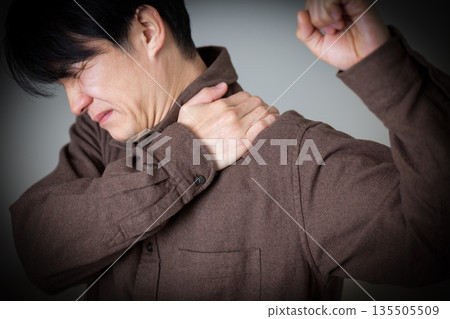 Middle-aged man suffering from stiff shoulders Middle-aged man suffering from stiff shoulders 135505509