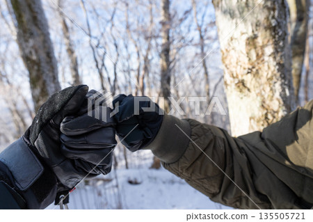 two people putting fists together two people putting fists together 135505721