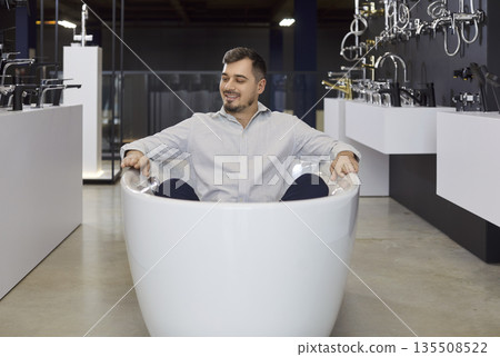 Man Client Trying Bathtub In Plumbing Store Man Client Trying Bathtub In Plumbing Store 135508522