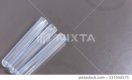 Plastic test tubes lined up horizontally and blank space. Medical, testing, and experimental background material. Plastic test tubes lined up horizontally and blank space. Medical, testing, and experimental background material. 135508575