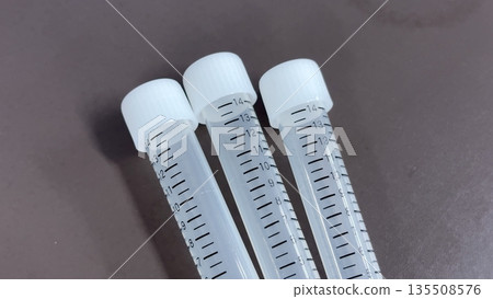 Medical, testing, and experimental image of graduated plastic test tubes lined up 135508576