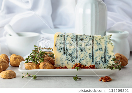 Gorgonzola cheese with walnuts, and thyme on a white table. Gorgonzola cheese with walnuts, and thyme on a white table. 135509201