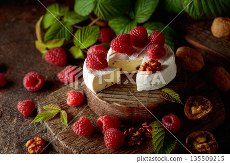 Camembert cheese with fresh raspberries and walnuts. 135509215