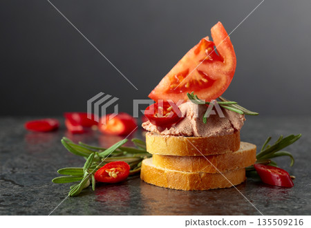 Bread slices with pate, tomato, red pepper, and rosemary. Bread slices with pate, tomato, red pepper, and rosemary. 135509216