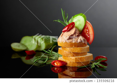 Bread slices with pate, tomato, cucumber, red pepper, and rosemary. 135509218