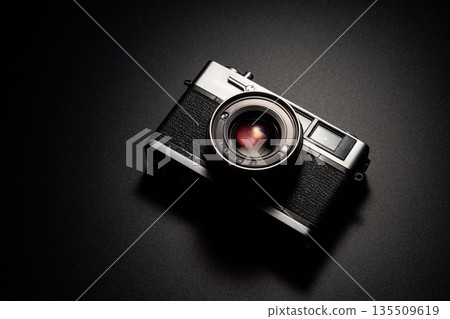 Old film camera in spotlight against a dark background Old film camera in spotlight against a dark background 135509619