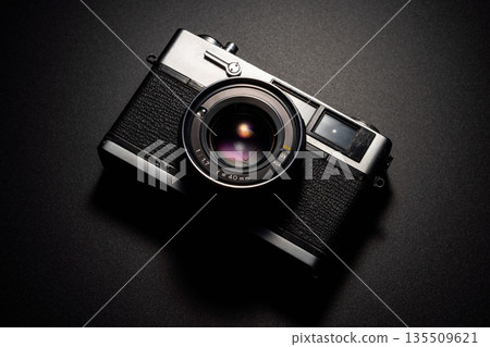 Old film camera in spotlight against a dark background Old film camera in spotlight against a dark background 135509621