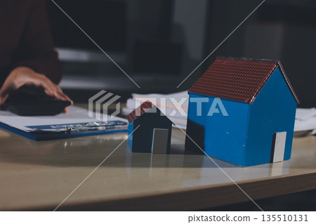 Customer signing a real estate contract in real estate agency. 135510131