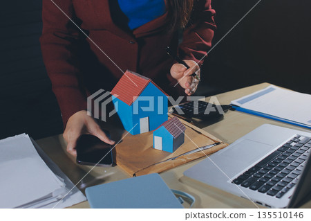 Customer signing a real estate contract in real estate agency. 135510146