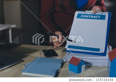 Customer signing a real estate contract in real estate agency. Customer signing a real estate contract in real estate agency. 135510148