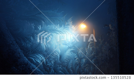 Frosted window with intricate ice patterns illuminated by streetlight at night 135510528