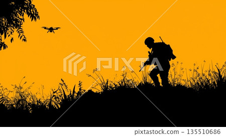 Silhouette of soldier with weapon observing drone against vibrant orange sunset backdrop 135510686