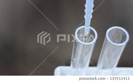 特寫鏡頭展現了醫療、檢測和實驗室工作中,用滴管將液體滴入塑膠試管的過程。 特寫鏡頭展現了醫療、檢測和實驗室工作中,用滴管將液體滴入塑膠試管的過程。 135511411