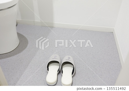 Slippers and part of a toilet bowl lined up in a clean toilet space. Slippers and part of a toilet bowl lined up in a clean toilet space. 135511492