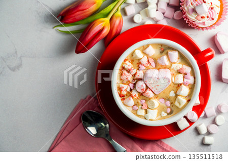 Valentine's Day background. Red cup of coffee with heart shaped marshmallows and ret tulips 135511518