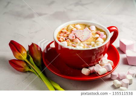 Valentine's Day background. Red cup of coffee with heart shaped marshmallows and ret tulips 135511538