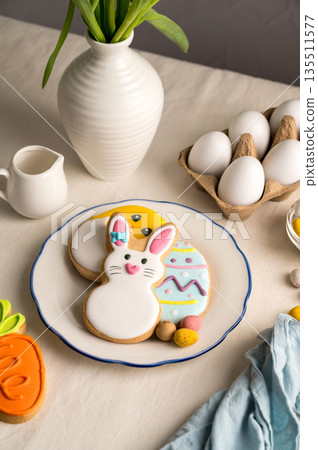 Easter festive background. Colourful easter cookies bunny, egg, chick and carrot. White spring tulips bouquet. Easter festive background. Colourful easter cookies bunny, egg, chick and carrot. White spring tulips bouquet. 135511577