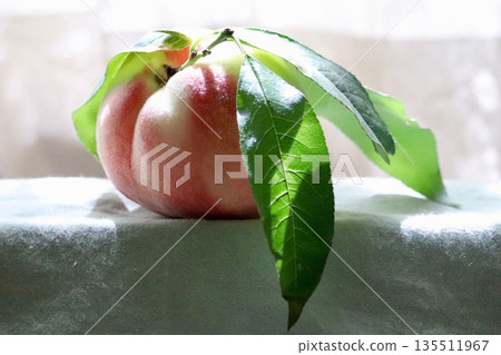 A peach with leaves sticking out A peach with leaves sticking out 135511967