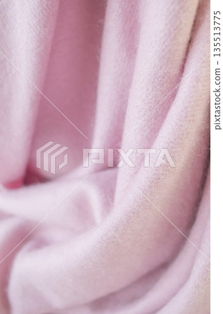 Pale pink cashmere scarf with fringe around the edge. Soft pink draped fabric texture. 135513775