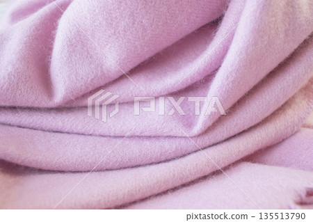 Pale pink cashmere scarf with fringe around the edge. Soft pink draped fabric texture. Pale pink cashmere scarf with fringe around the edge. Soft pink draped fabric texture. 135513790