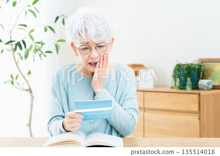老婦人一邊看著存摺一邊思考 135514018