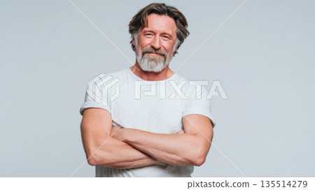 A middle-aged person smiles with pleasant surprise while standing confidently with arms crossed. The background is clean and simple. 135514279