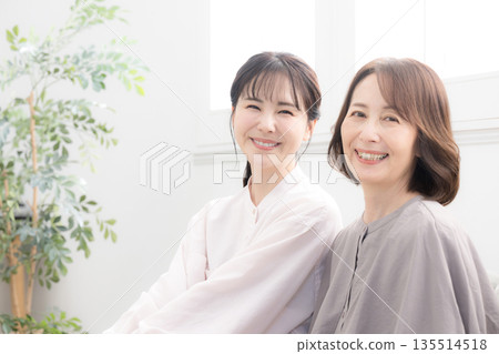 Smiling mother and daughter standing close together, image of happiness, full body, looking at camera Smiling mother and daughter standing close together, image of happiness, full body, looking at camera 135514518