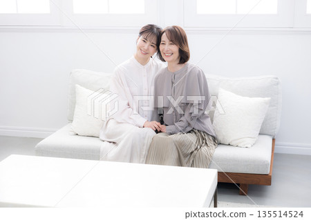 Smiling mother and daughter standing close together, image of happiness, full body, looking at camera 135514524