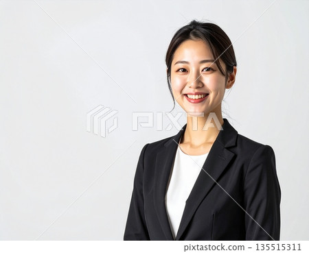 Portrait of a young female business person smiling on a white background (with space, for advertising) 135515311
