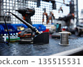 A soldering iron is resting on a worktable with a soldering iron and solder 135515531