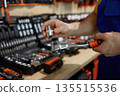 Worker is diligently working on a wrench inside a store 135515536