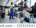 A male worker in a store looking at compressors 135515541