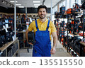 Welder worker is holding a welding machine inside a store 135515550