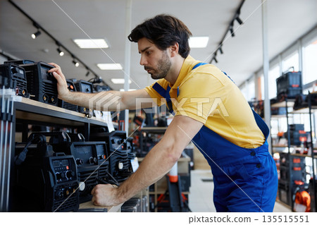 A person is diligently checking a new welding machine 135515551