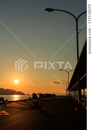愛媛郡八幡濱港的日落，碼頭和路燈的輪廓在夕陽下若隱若現。 135516079