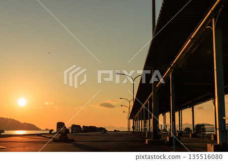 愛媛郡八幡濱港的日落，碼頭和路燈的輪廓在夕陽下若隱若現。 135516080