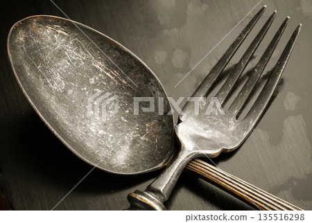 Close-up of Ancient worn vintage cutlery on the black background. 135516298