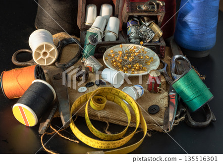Spools of thread of various colors, Thimbles in small wooden treasure chest, Steel scissors, Sewing needles stuck in a green miniature spools thread and Measuring tape including pins in small round 135516301