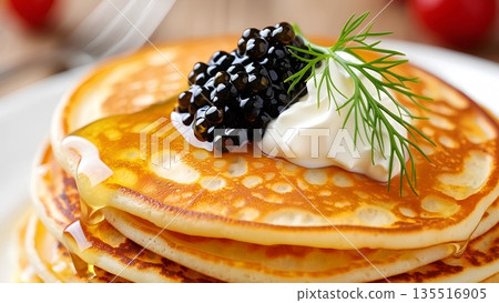 Gourmet blini or pancakes elegantly topped with black caviar, a dollop of sour cream, and fresh dill, a luxurious russian-inspired appetizer 135516905