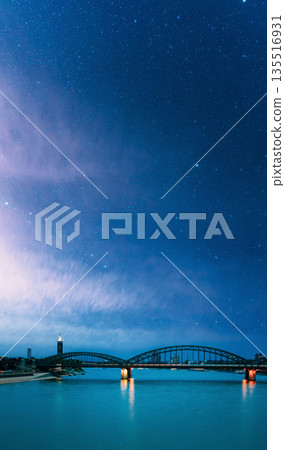 Night View Of Hohenzollern Arch Bridge Over The River Rhine, Germany. Europe. Cologne. Night starry sky with stars in blue heaven 135516931