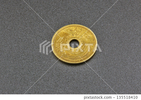 Japanese coin with hole on dark background 135518410