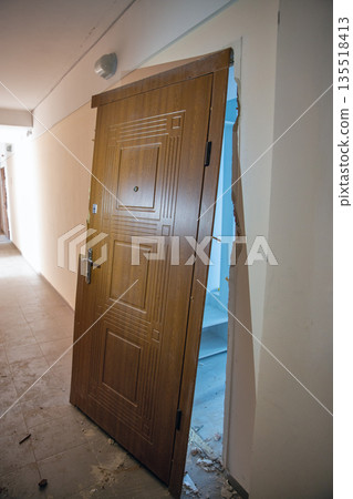 Damaged apartment entrance door in hallway during renovation. 135518413
