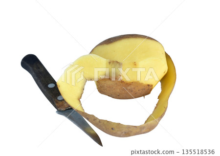 Half-peeled potato and a knife. Half-peeled potato and a knife. 135518536