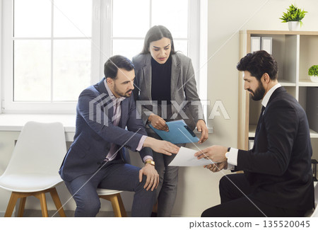 Office businesspeople sitting interacting reviewing contract documents, handing paper, explaining Office businesspeople sitting interacting reviewing contract documents, handing paper, explaining 135520045