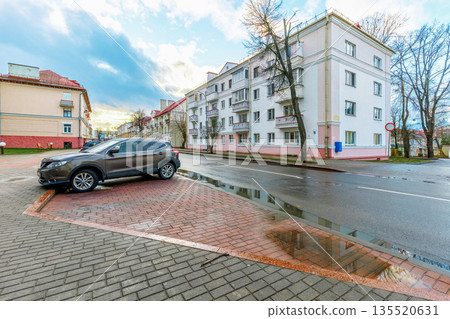 Dark SUV parked on a paved lot near urban residential houses 135520631