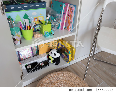 New modern children toys in white cupboard on shelf. Cleaning and storage in home. Design and order.  135520742
