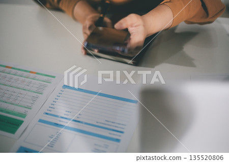 Business woman using calculator to calculate financial report, working at office with laptop computer on table. Asian female accountant or banker making calculations. finances and economy concept Business woman using calculator to calculate financial report, working at office with laptop computer on table. Asian female accountant or banker making calculations. finances and economy concept 135520806