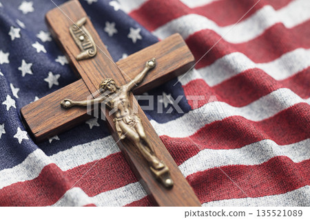 Wooden crucifix on wavy American flag 135521089